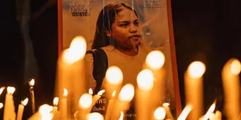 Candles lit in front of a picture of Netiporn during Tuesday night's vigil in front of the South Bangkok Criminal Court.