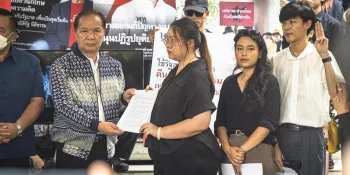 Activists submitting their petition to government representatives. Behind them, other activists are holding posters of the Pheu Thai Party’s past proposals to ensure bail for political prisoners. (Photo from iLaw)