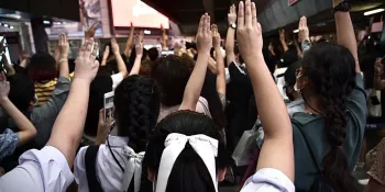 Students and members of the public displaying the three-finger salute while the National Anthem played during a protest at the Asoke BTS station on 20 October 2020. (Photo from Free Youth)