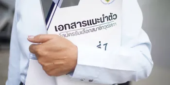 A senator candidate at the national-level selection holding a booklet of candidate information published by the Election Commission