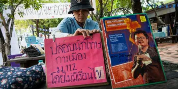 A participant at today's gathering at parliament holding a sign calling for the release of political prisoners detained for royal defamation. (Photo by Ginger Cat)