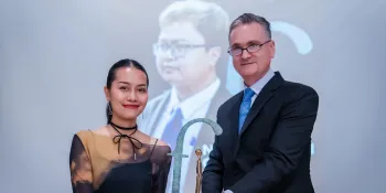 Pathomporn Kaewnoo (left) receiving the award on behalf of Anon and his family (Photo by Ginger Cat)