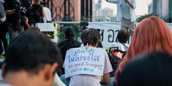 A protester has a sign taped to his back saying "The election was not transparent. We need transparency now." (Photo by Ginger Cat)